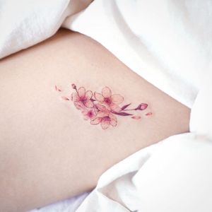 Cherry blossom tattoo by March Tattoo #MarchTattoo #cherryblossomtattoos #cherryblossom #flowers #floral #nature #plant #cherryblossomtattoo #color #fineline #watercolor #minimal #small #tiny #petals #pink