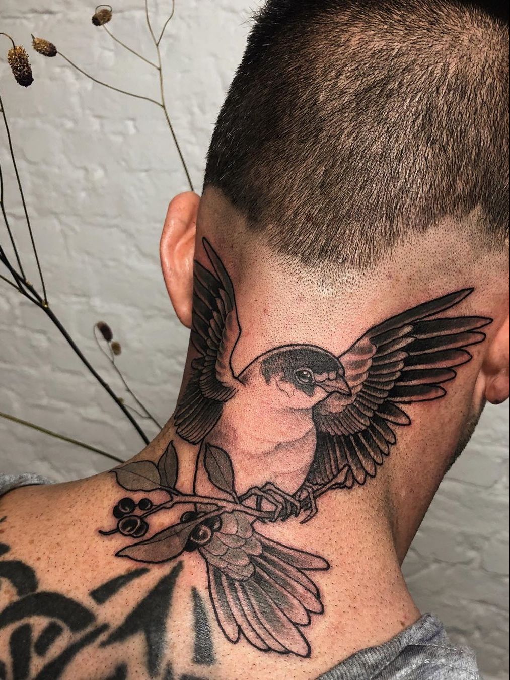 Swallow tattoo on the left side of the neck.