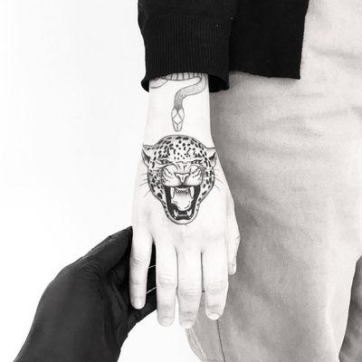 Hand tattoo by Jake Haynes aka Pokeeeeeeeoh #JakeHaynes #Pokeeeeeeeoh #besttimetogettattooed #gettattooed #winter #besttattoos #handtattoo #leopard #junglecat #cat #illustrative