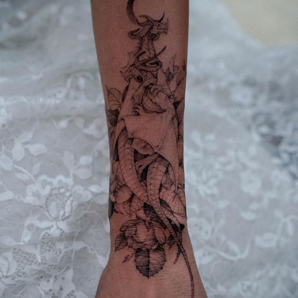 Dragon forearm tattoo by Woohwa Fable #woohwafable #dragonforearmtattoo #illustrative #fineline #Moon #flowers #dragontattoos #dragontattoo #dragon #mythicalcreature #myth #legend #magic #fable