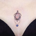 Small chest tattoo by Song E Tattoo #SongETattoo #songe #chesttattoo #jewel #moonstone #ornamental 