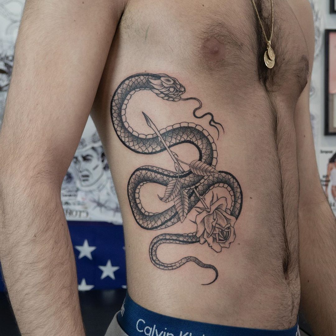 Fine line snake tattoo on the rib