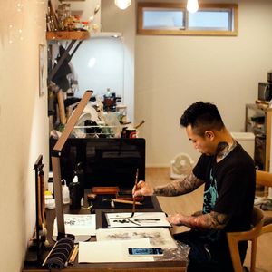 Ichi Hatano in his studio doing callipgraphy for the cover of his book