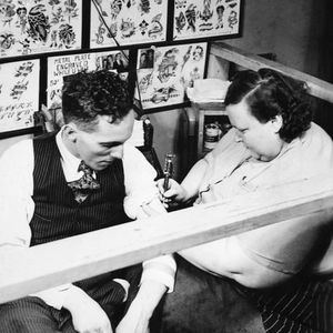 Dainy Dotty tattooing a client
