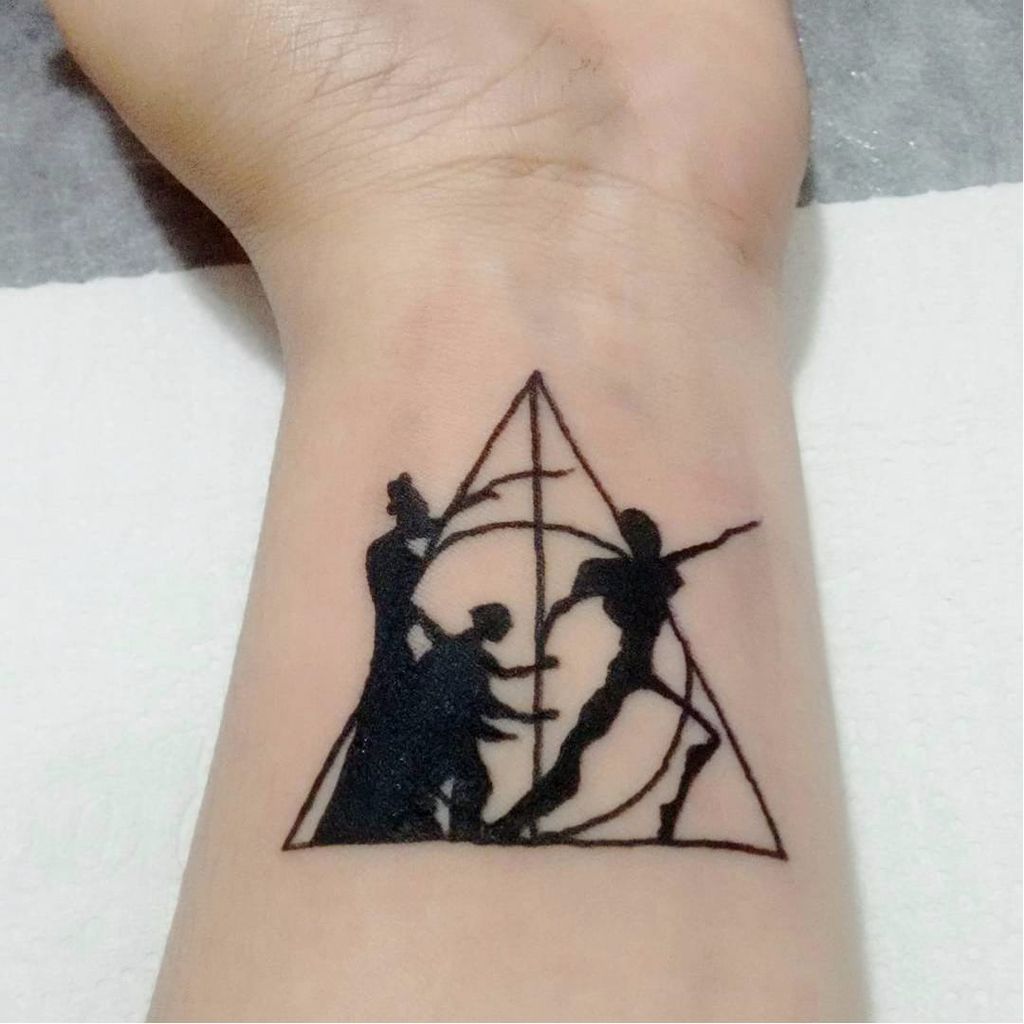 Símbolo das Relíquias com os três irmãos do conto! Sabe quem fez essa tattoo? Conta pra gente! #reliquiasDaMorte #TheDeathlyHallows #HarryPotter #HarryPotterTattoo