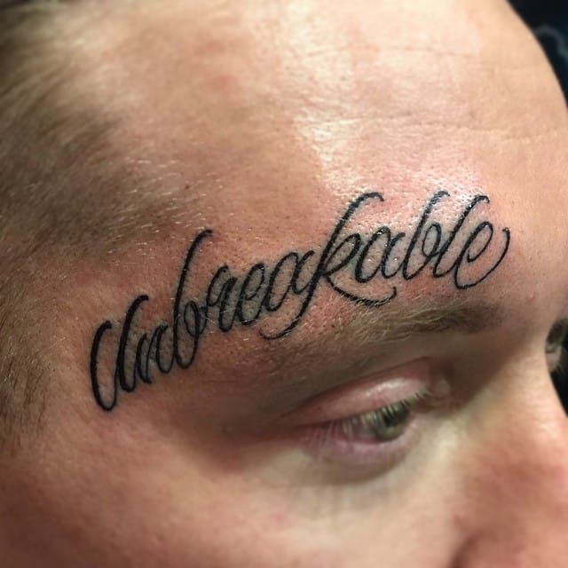 above eyebrow lettering tattoo