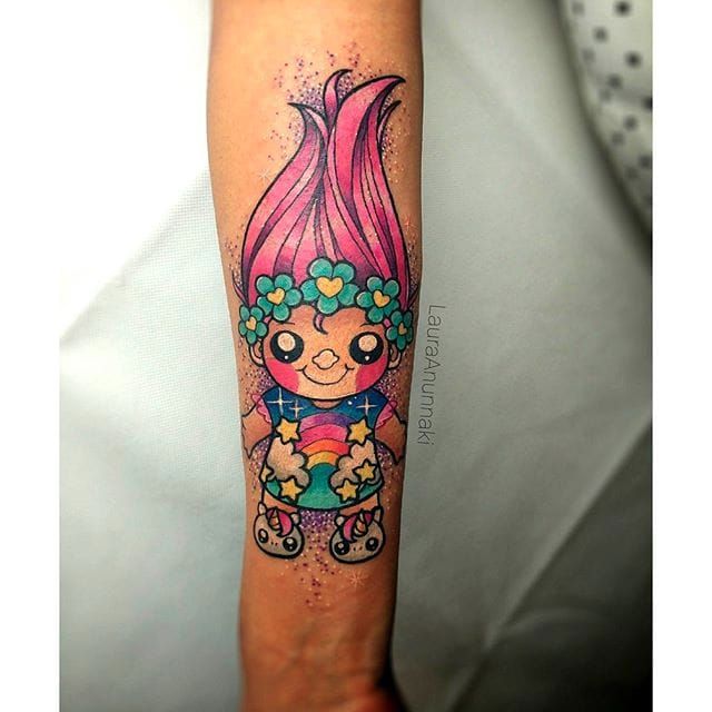 Troll doll tattooed on the inner forearm