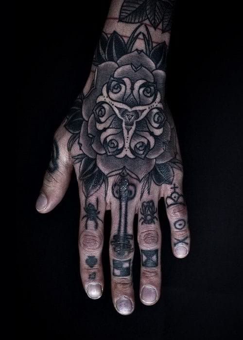 Choose a finger tattoo design that complements your hand tattoo well. Work by Thomas Hooper.