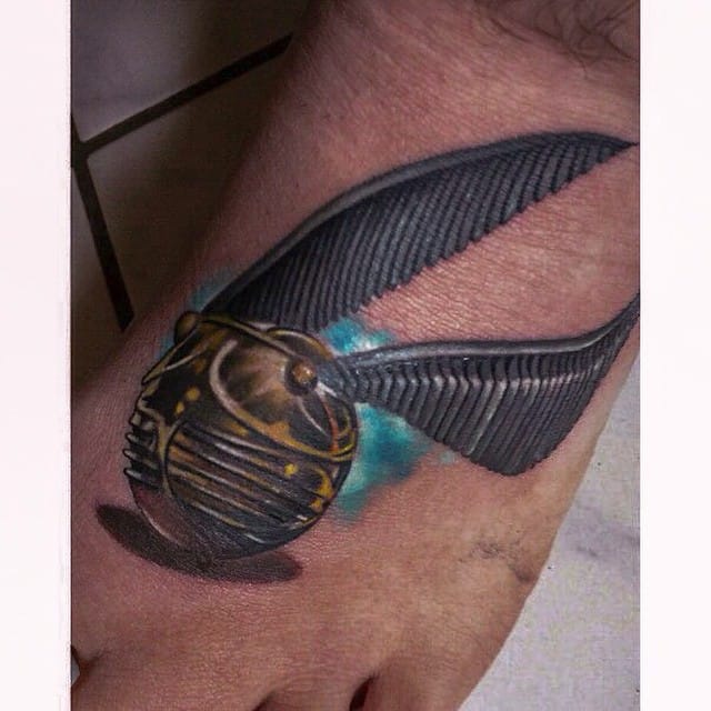 Den Hor tattooed a realistic Golden Snitch on the foot of his client. #HarryPotter #tribute #fantattoo #GoldenSnitch #realism #realistic