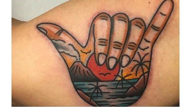 Minimalist shaka sign tattoo on the wrist