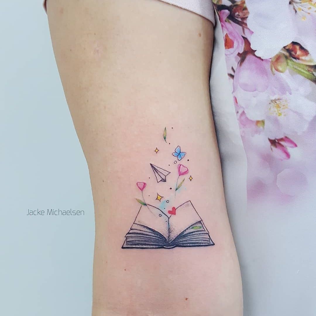 Tiny fine line book tattoo on the wrist