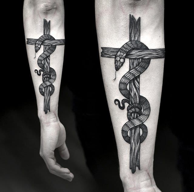 Here forming a cross in a jaw-droppping tattoo by Kamil Czapiga...