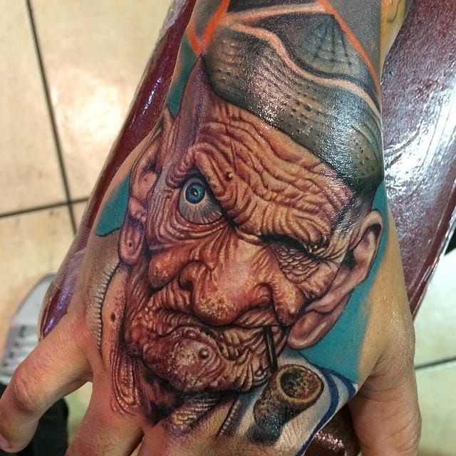 Bold hand tattoo by Roman Abrego.