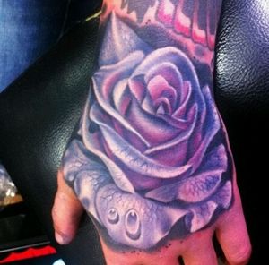 Beautiful colored rose hand tattoo.