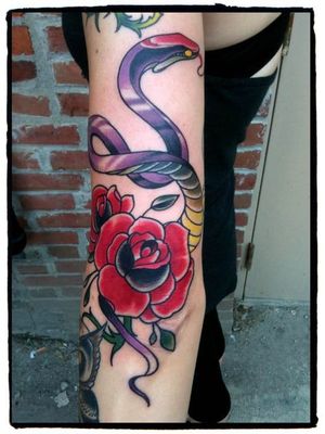 Colorful snake rose artwork on the upper arm