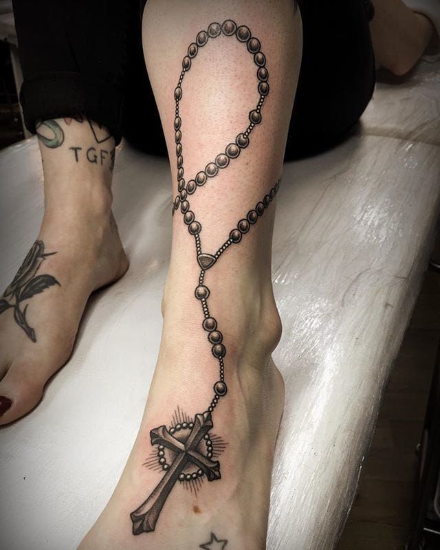 Tiny crescent and rosary tattoos.