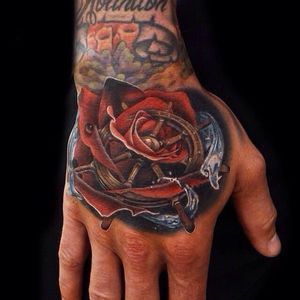 Rose and ship helm morph tattoo on Andres Acosta.