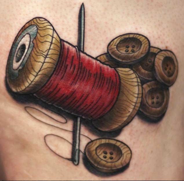Hand poked thread and needle tattoo located on the