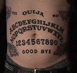 Stomach ouija board tattoo.