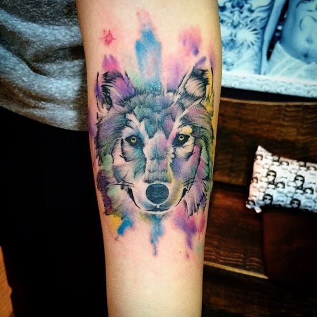 Watercolor wolf tattoo on the right inner forearm