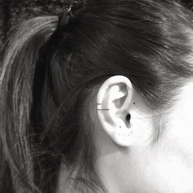 Two lines and three dots tattoo on the right ear.