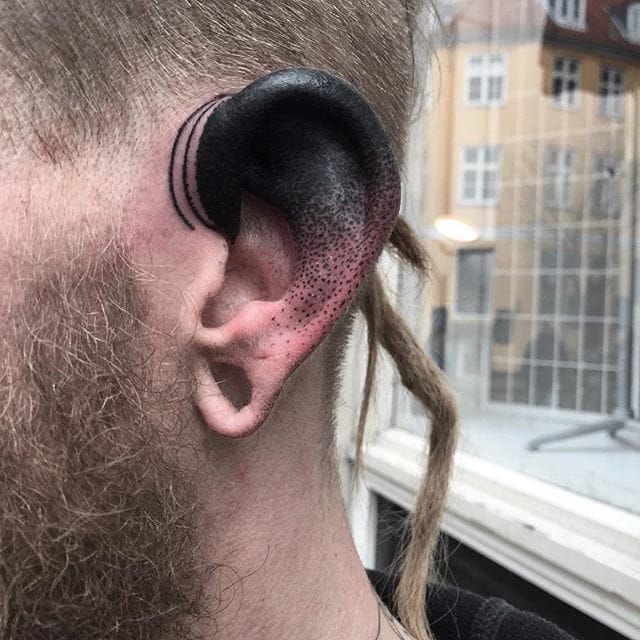 Line tattoo going from the back of the ear to the arm.