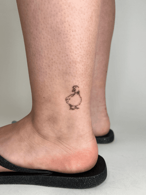 Delicate and illustrative tattoo of a tiny duck by Emma InkBaby, expertly executed with fine line details.