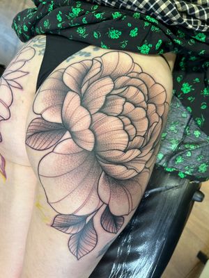 This illustrative floral tattoo features a stunning peony flower, expertly executed by tattoo artist Lawrence Canham.