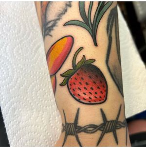 Embrace the timeless beauty of a juicy strawberry with this neo-traditional tattoo by the talented artist Lawrence Canham.