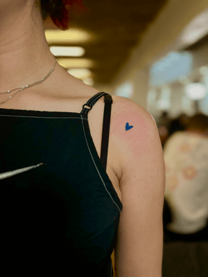 Minimalistic yet striking heart tattoo in blue ink, expertly designed by artist Ruth Hall.