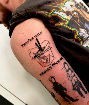 Blackwork tattoo by Miss Vampira featuring horror-themed takeout noodles with illustrative lettering.