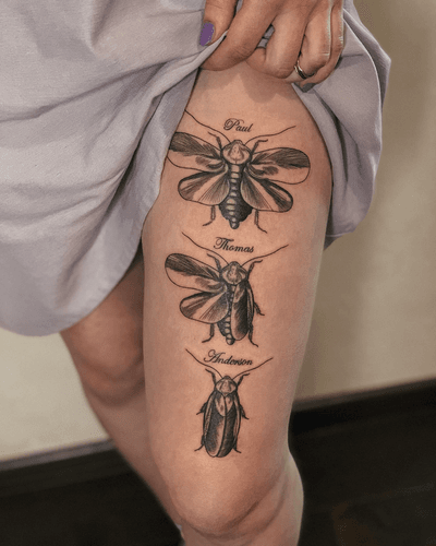 Alona Hamova's blackwork tattoo features a detailed etching of a cicada and a beetle with small lettering.