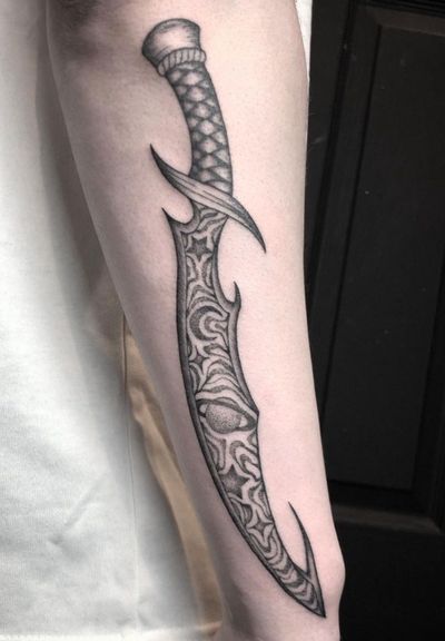 Unique black and gray dotwork dagger tattoo design by Amandine Canata, combining fine details and shading for a stunning result.