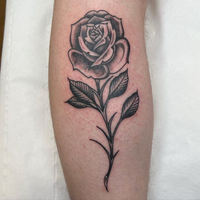 Get a beautiful traditional rose tattoo by renowned artist Cappi, known for his intricate and stunning designs. Perfect for lovers of classic tattoo art.