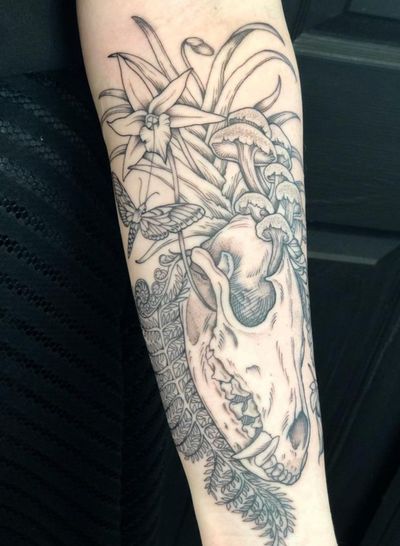 Experience the beauty of nature with this unique tattoo featuring butterflies, flowers, skulls, orchids, ferns, plants, and mushrooms. Created by the talented artist Amandine Canata.