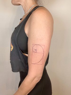 Fine line and geometric tattoo featuring Fibonacci spiral design, expertly done by tattoo artist Alina Amberland.