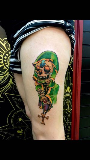 Vibrant and bold new school tattoo on upper leg by Sandro Secchin, featuring praying hands and sugar skull motifs.