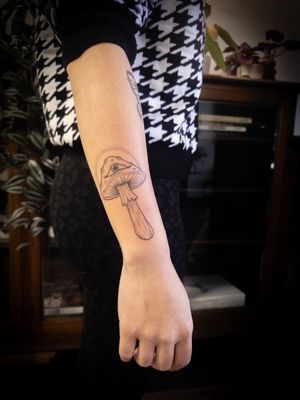 Illustrative fine line tattoo by Steffan Eagle combining a mystical evil eye and a whimsical mushroom design.