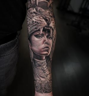 Realistic black and gray tattoo of a fierce woman embodying a Mayan jaguar huntress.