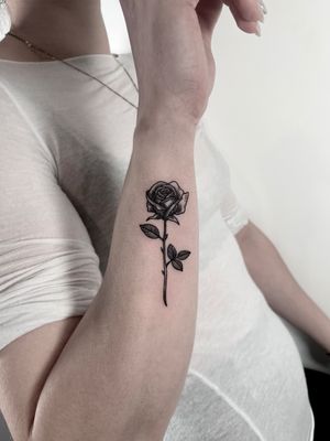 Exquisite blackwork tattoo showcasing a detailed woodcut rose, expertly rendered in fine line style by tattoo artist Robin Rossi.