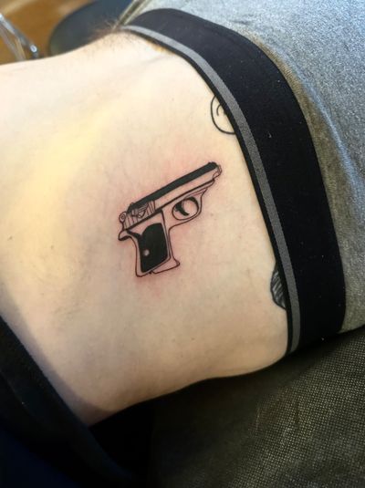 Get a sleek and bold blackwork tattoo of the iconic James Bond Walther PPK gun, expertly done by Miss Vampira.