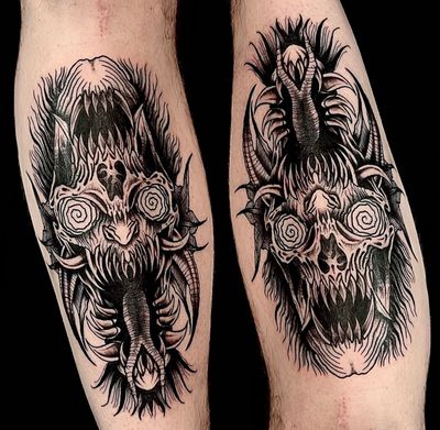 Get double the horror with this blackwork skull tattoo by Ker Kusterbeck, featuring a sinister monster design with a hidden meaning.