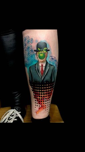 Vivid and unique forearm tattoo featuring an apple and hat in a geometric watercolor style by artist Sandro Secchin.