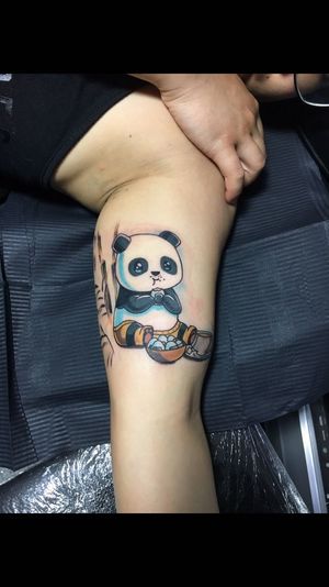 Get inked with a cute new school design by artist Sandro Secchin, featuring a playful panda and egg on your upper arm.
