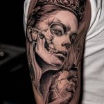 A black and gray chicano and realism tattoo by Warren Mullins featuring a lady with a crown symbolizing death.