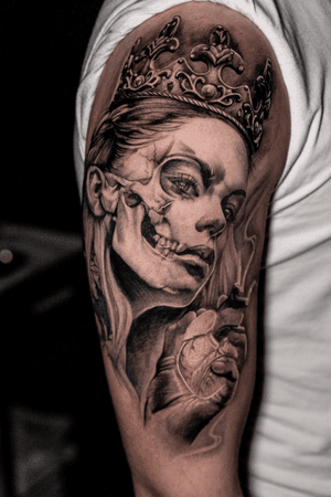 A black and gray chicano and realism tattoo by Warren Mullins featuring a lady with a crown symbolizing death.