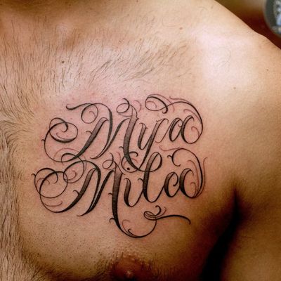 Name Mía tattooed on the side boob.