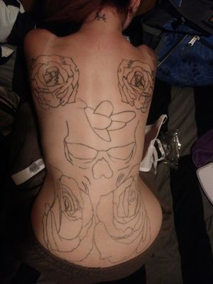 the outline done so far on my back. roses with skull heads all stitched together on the top, skull in the middle with a death moth in the head and roses on the bottom.