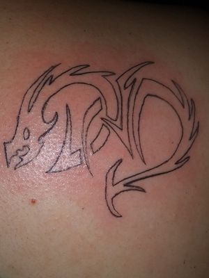 Tribal tattoo of a dragon shaped as a heart spelling the word DAD