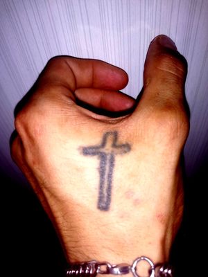 Croix de jésus sur la main gauche fait maison mais qui va être rattraper pare un tatoueur 